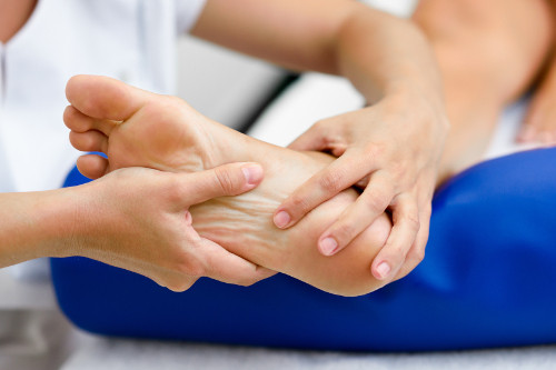 lekarz bada łuszczycę stóp - zmiany na podeszwie