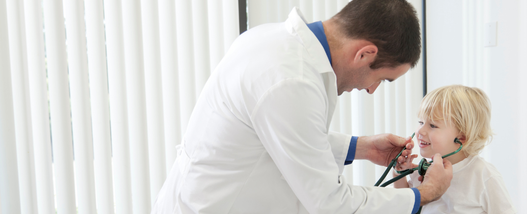 lekarz z stetoskopem słuchający serca dziecka