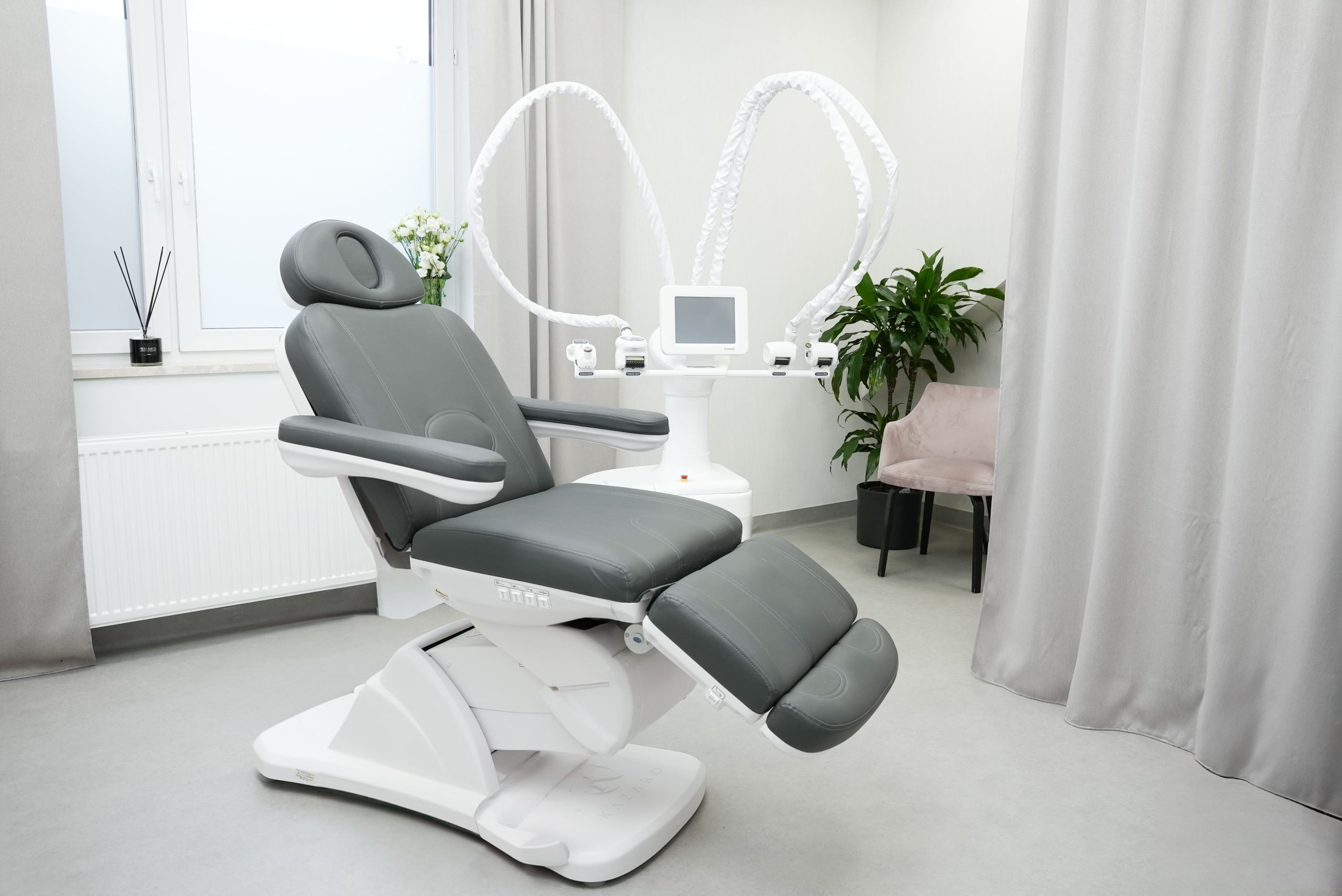 gabinet kosmetologiczny, na środku profesjonalny fotel, a obok niego ICOONE laser do modelowania sylwetki