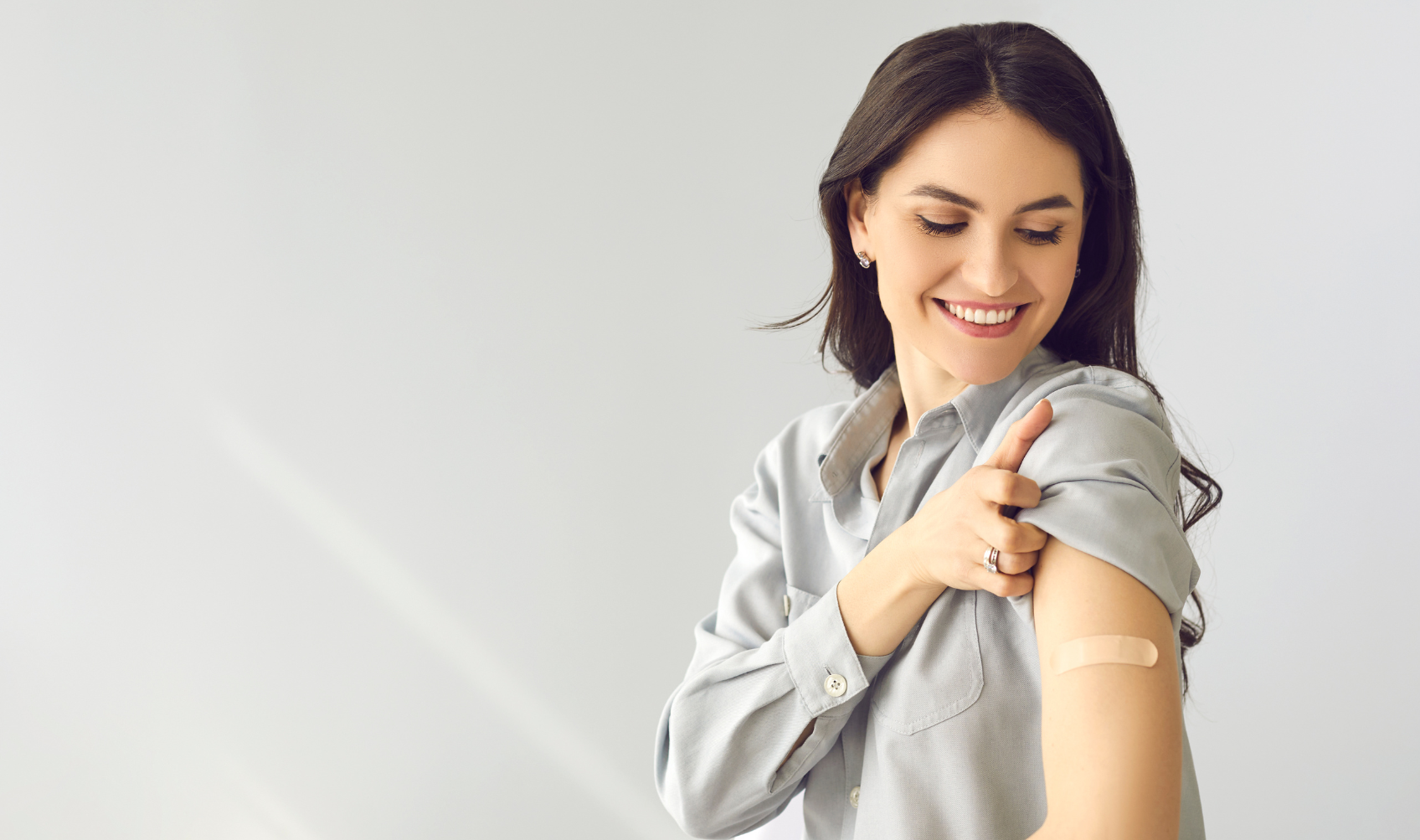 młoda kobieta po szczepieniu z plastrem na ramieniu