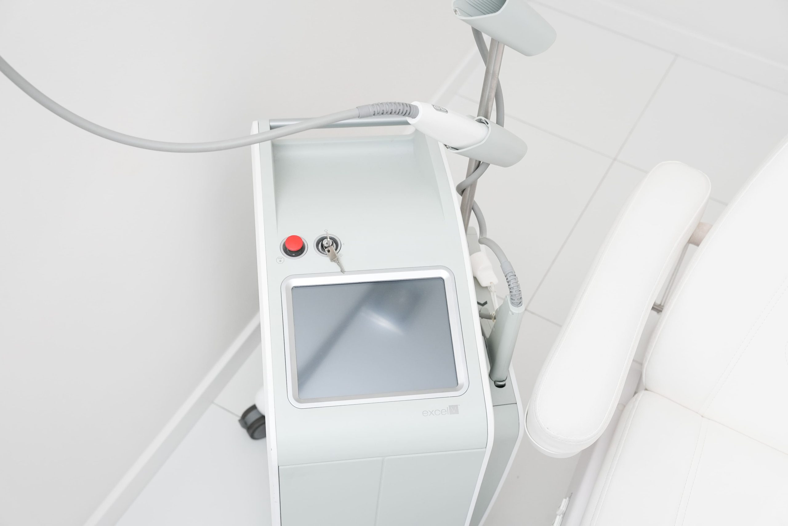 Laser Cutera Excel V stojący przy fotelu dermatologicznym w placówce FEBUMED