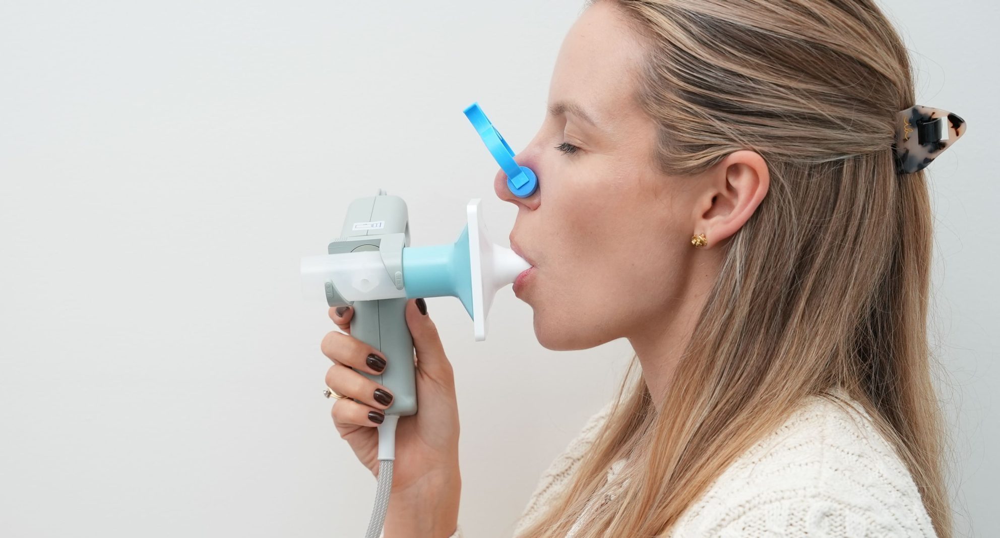 Pacjentka dmuchająca w ustnik podczas badania spirometrycznego