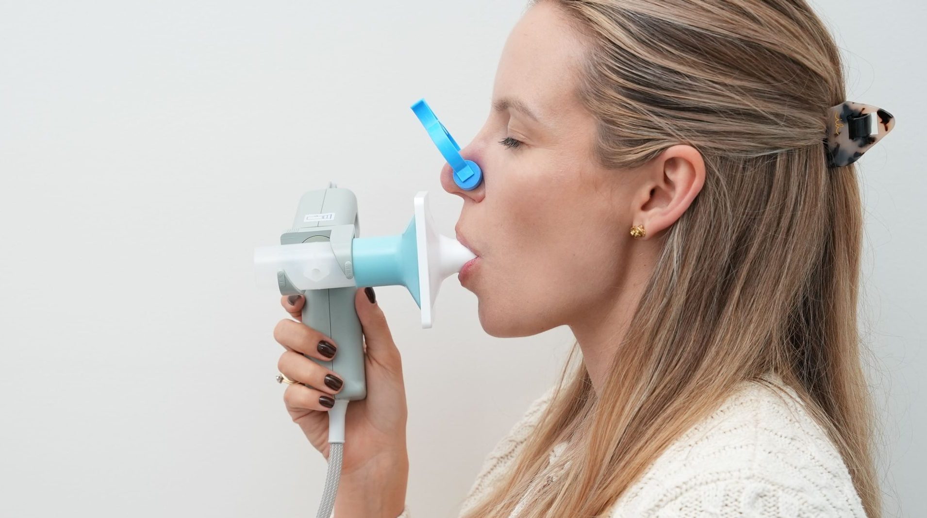 Pacjentka dmuchająca w ustnik podczas badania spirometrycznego